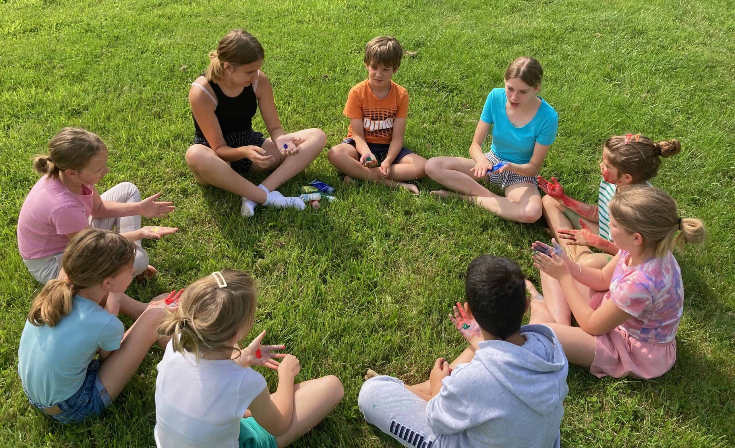 Groepje kinderen en jongeren in een kring tijdens het pianokamp